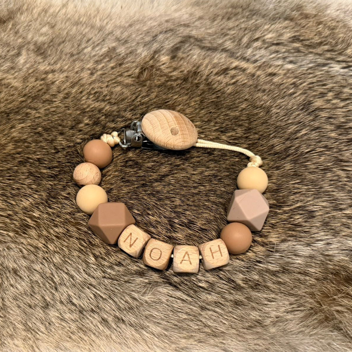 Gepersonaliseerd speenkoord met naam Noah in beige en bruintinten